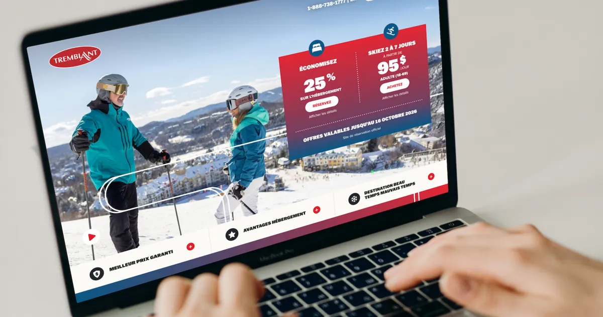 Un ordinateur portable affiche le site de Tremblant, avec deux skieurs sur une piste enneigée et une promotion rouge indiquant « ÉCONOMISEZ 25 % » et « SKIEZ À 95 $ »; des mains utilisent le clavier.