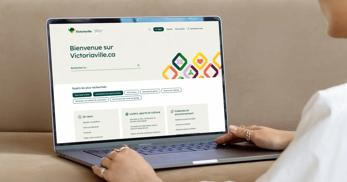 Une personne consulte sur un ordinateur portable la page d’accueil de Victoriaville.ca, où l’on lit « Bienvenue sur Victoriaville.ca ».