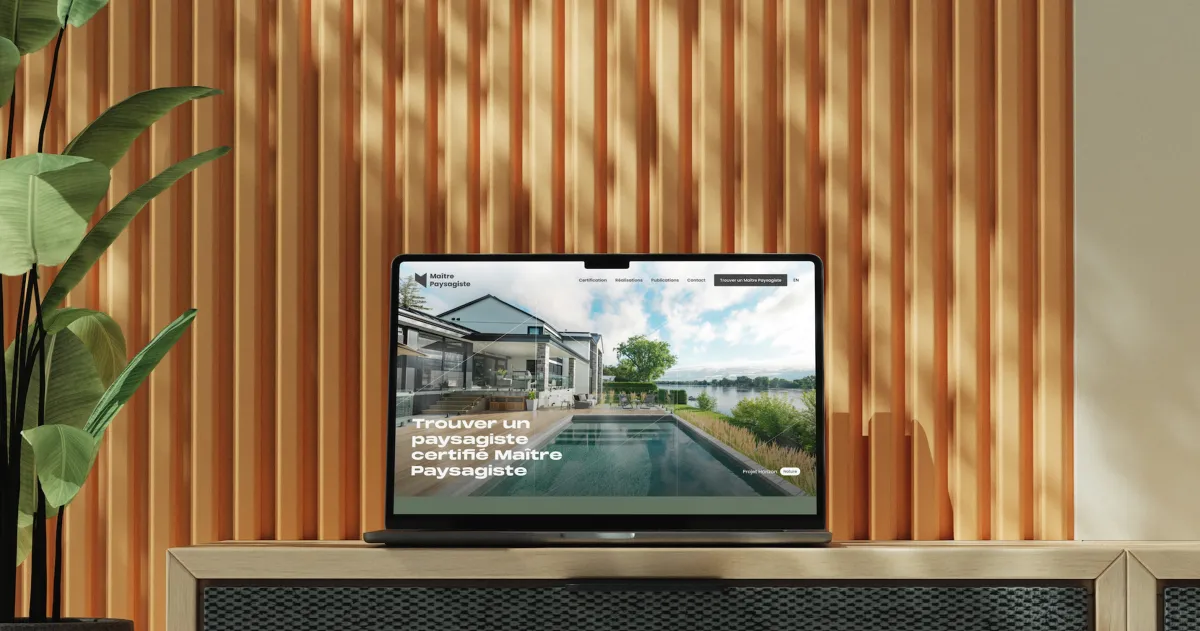 Ordinateur portable affichant le site de McMaster University avec le texte « Trouver un programme certifié de maîtrise pour accélérer votre carrière », posé sur un meuble devant un mur à panneaux de bois, avec une plante à gauche.